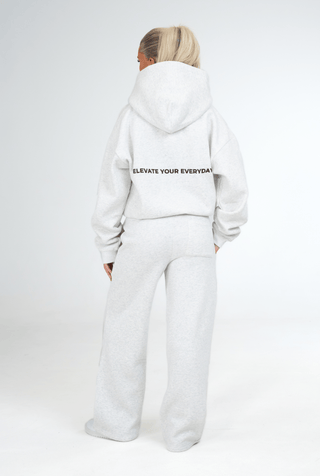 Person wearing a grey hoodie and pants with 'KENZEN' branding on a white background