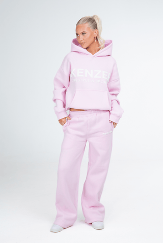 Person wearing a pink tracksuit on a white background