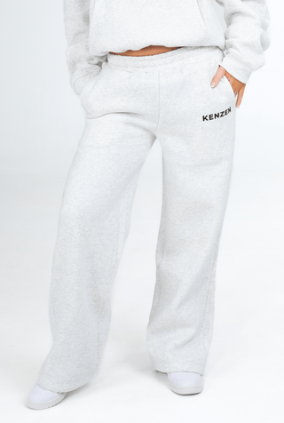 Person wearing a grey hoodie and pants with 'KENZEN' branding on a white background
