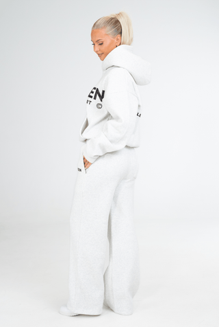 Person wearing a grey hoodie and pants with 'KENZEN' branding on a white background